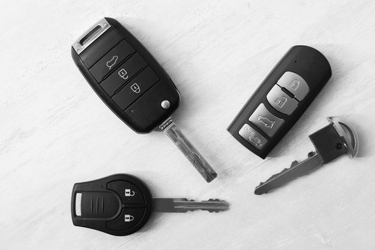Flat lay composition with different car keys on light background, top view