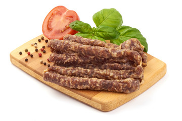 Dried thin pork sausages, smoked meat, close-up, isolated on white background