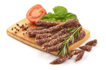 Dried thin pork sausages, smoked meat, close-up, isolated on white background