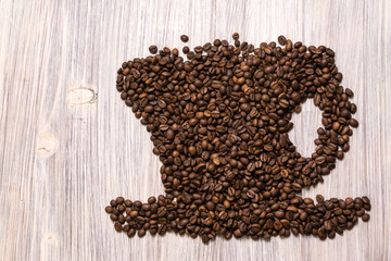 Roasted coffee beans like a cup on a wooden background