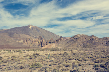 Fototapeta na wymiar Panoramic view of spectacular volcanic landscape with cone raising high above the gorund.