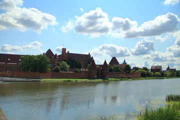 Fototapeta na wymiar Malbork Castle across the river Nogat