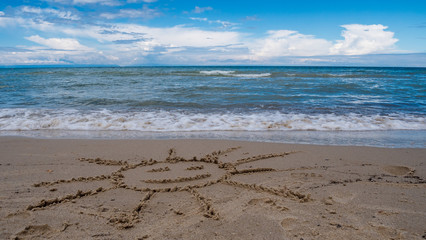 Sun smiling on the beach with a beautiful sea