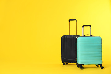 Stylish suitcases on color background. Space for text