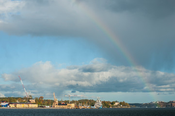 Naklejka na ściany i meble Rainbow over autumn city. Stockholm on a autumn sunny day. City port