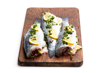 Fresh whole sea bass fish with lemon and herbs isolated on a white