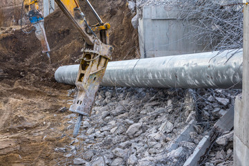 Professional demolition of reinforced concrete structures using industrial hydraulic hammer. Rods...