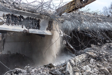 Professional demolition of reinforced concrete structures using industrial hydraulic hammer. Rods...