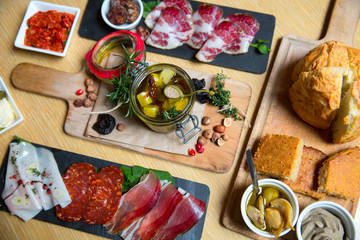 Cutting board with prosciutto, salami,bread on dark stone background.