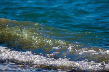 sea landscape is a pebbly beach with waves in white foam