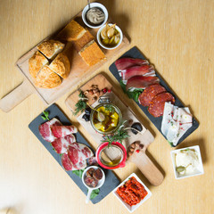 Fototapeta na wymiar Cutting board with prosciutto, salami,bread on dark stone background.