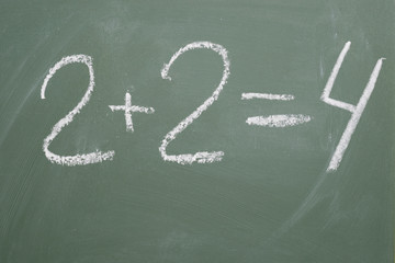 inscription in chalk on a blackboard 2 plus 2