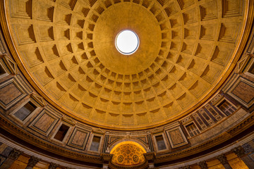 Fototapeta na wymiar Pantheon Dome - A wide-angle view of 1st-century coffered concrete dome, lighted up at evening, of the Pantheon, a church converted from an ancient Roman temple. It's now a state property. Rome, Italy