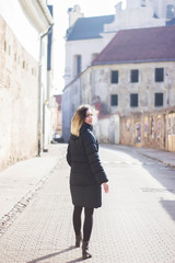 A young woman goes ahead and turns to look at the camera. Old Town Background