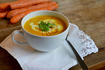 hausgemachte frische Möhrencremesuppe mit Petersilie und Chilifäden	