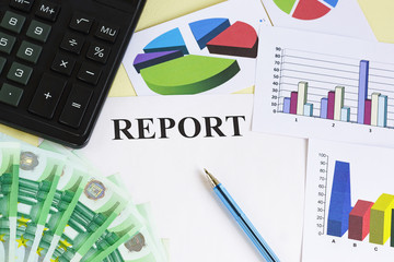 Preparation of the financial report. Money, calculator, pen, color charts and diagrams on the table