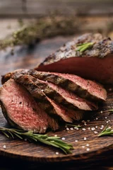  Juicy medium Beef Rib Eye steak slices on wooden board with herbs spices and salt. © nata_zhekova