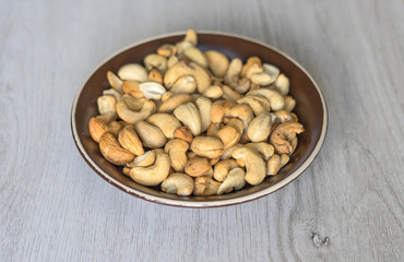 Healthy food  for background image close up cashew nuts.  Nuts texture on white grey table top view on the cup plate