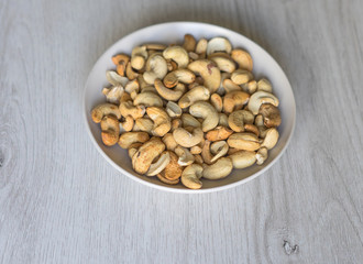 Healthy food  for background image close up cashew nuts.  Nuts texture on white grey table top view on the cup plate