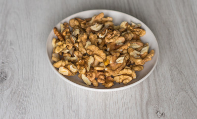 Healthy food  for background image close up walnuts.  Nuts  texture on white grey table top view on the cup plate