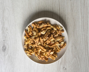 Healthy food  for background image close up walnuts.  Nuts  texture on white grey table top view on the cup plate
