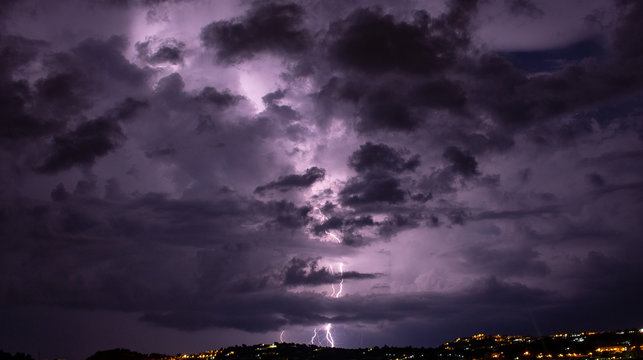 Bacoli, Italy. A sudden storm arrives and illuminates the city with the Fusaro lake in the foreground.