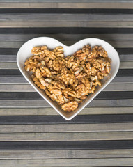 Nuts arranged in heart  on background. Healthy Food image close up walnuts nuts. Love Texture