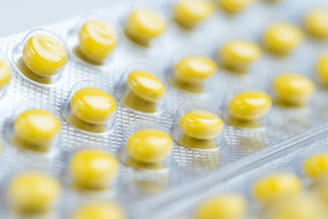 Medicine yellow pills packed in blisters. Macro. Copy space for text