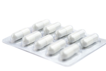 Medicine white pills packed in blisters on blue background.