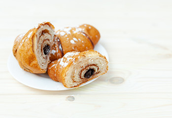 Fresh Croissant with chocolate on the white wooden background