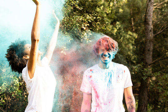 Couple throwing colorful powder paint, celebrating Holi, Festival of Colors