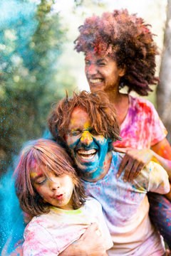 Family full of colorful powder paint, celebrating Holi, Festival of Colors