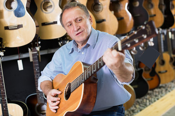 Man is playing on acoustic guitar