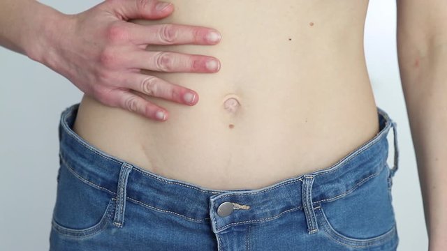 slim girl in too big jeans showing her belly