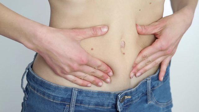 slim girl in too big jeans showing her belly