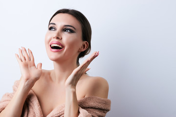 Happy beautiful young woman with clean fresh skin touch her face, close-up.