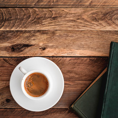 Books and cup of coffee on wooden table. Top view.