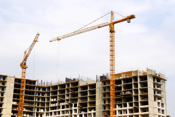 Construction site background. Hoisting cranes and new multi-storey buildings. Industrial background.