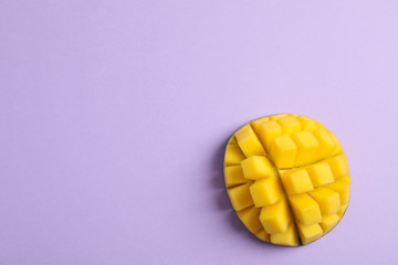 Cut tropical ripe mango and space for text on color background, top view