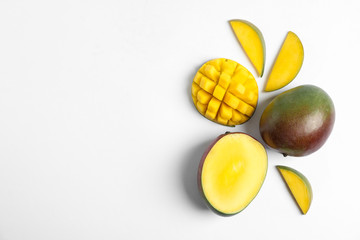 Flat lay composition with ripe mangoes and space for text on white background