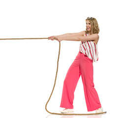 Happy Young Woman In Red Wide Leg Trousers Is Pulling The Rope