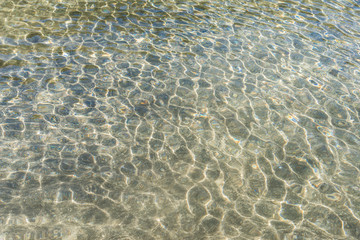 Transparent water surface and sand on the lake bottom