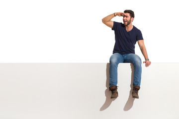 Happy Handsome Man Is Sitting On A Top, Looking Away And Talking