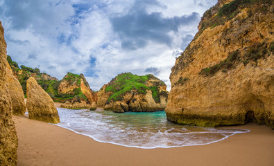 Famous rock formation in a bay on the beach of Tres Irmaos in Alvor, Portimão, Algarve, Portugal, Europe. Praia dos Tres Irmaos. View between two rocks.