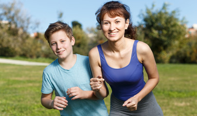 Woman and boy running outdoors