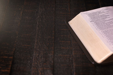 Bible on a Wooden Table in a Dark Environment