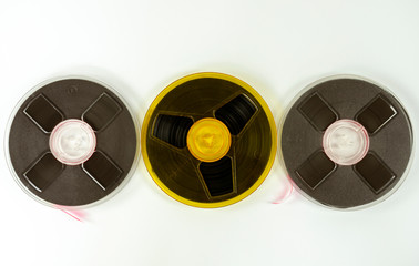 three audio tapes on a reel of different colors, on a white background