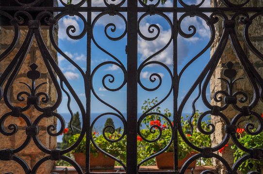 Wrought iron gate with sea and flowers in the background