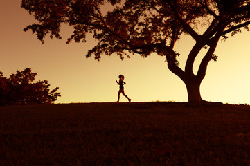 silhouette of woman running at sunset 