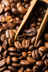 Black fried coffee beans on dark textured background